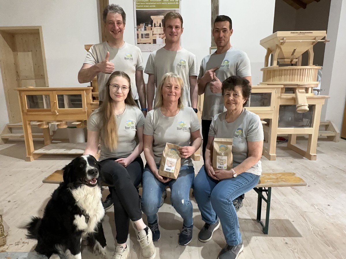 die Familie Obermayer und ihr Mitarbeiter mit Hofhund in der hofeigenen Getreidemühle