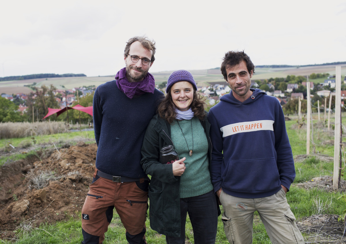 Zwei Männer und eine Frau auf einer landwirtschaftlichen Projektfläche