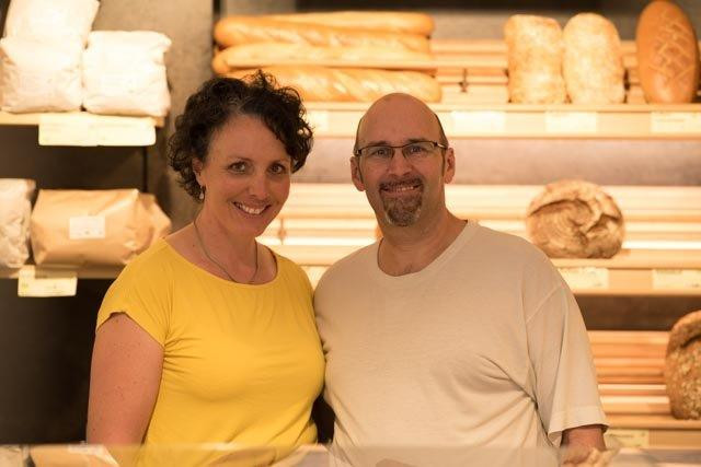 Barbara und Michael Wahlich vor Brotregalen in ihrem Bäckerladen