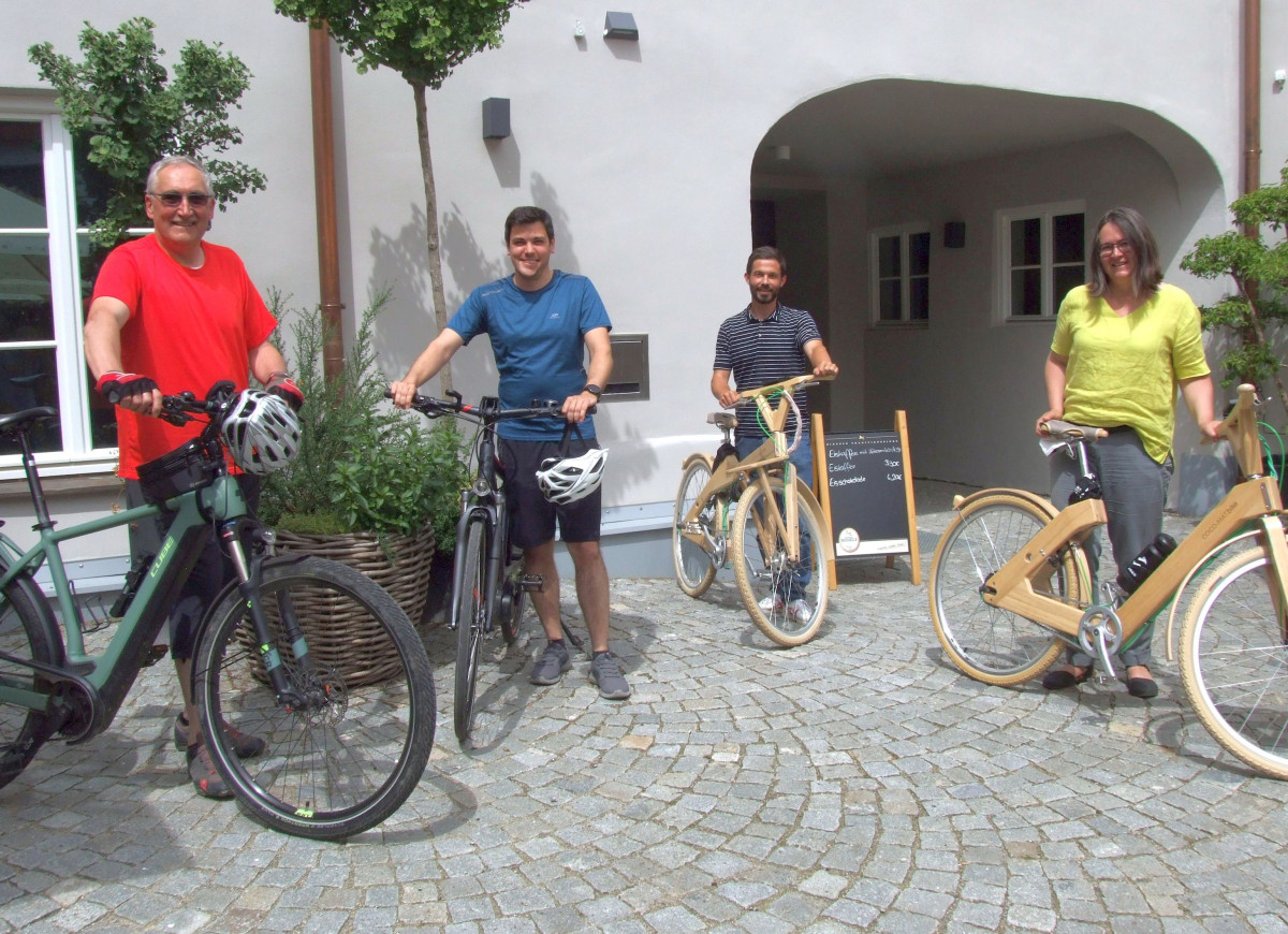 Das Foto zeigt mehrere Personen mit Fahrrädern.